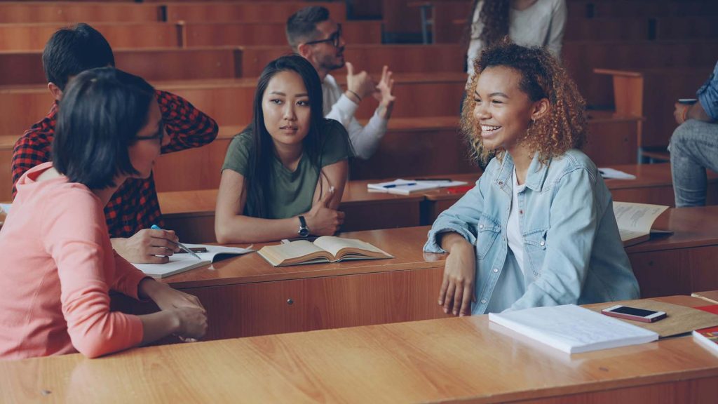 Young diverse students getting ready for lecture smiling